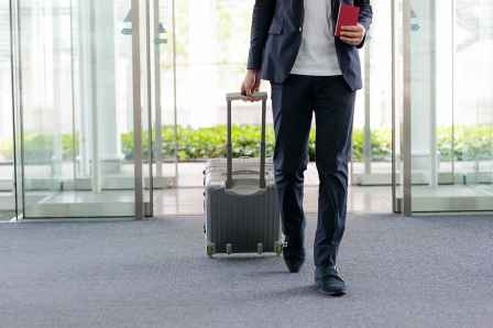 Foto: Mann mit Koffer am Flughafen