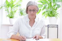 Foto: Ältere Dame bearbeitet Unterlagen